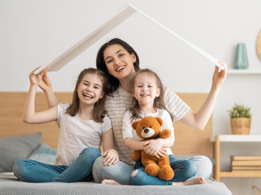 Mutter mit zwei Töchtern mit Dach über dem Kopf